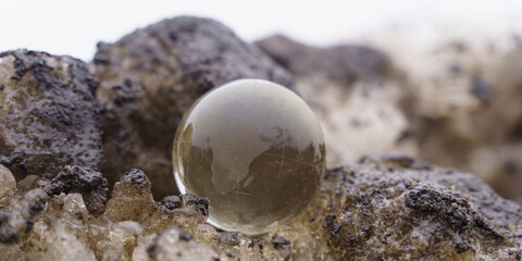 The glass ball lies on a dirty snowdrift nearby.