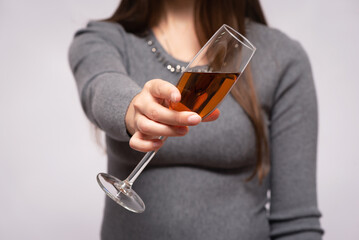 Woman holds in hand a glass of alcohol close up. The toast.