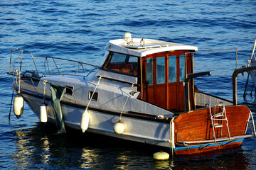 Fototapeta na wymiar An old type of yacht boat anchored in the harbor on a sunny day