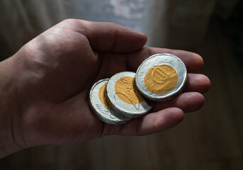 Chocolate euro coins held in the palm of your hand. European economic situation - concept.