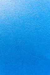 Vertical background of blue rippled paper. Texture of rough blue paper