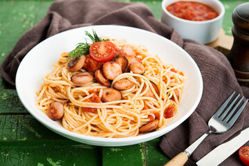 Pasta with sausages and tomato sauce on a rustic background