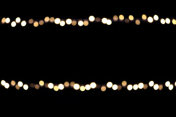 Bokeh on Christmas night. Natural bokeh outdoors in yellow and white tones on black background. Blurred background with Christmas illumination.  