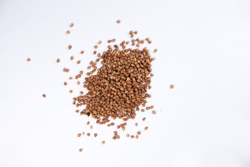 Pile of buckwheat on white background. Buckwheat seeds isolated on white background
