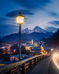 Berchtesgaden city lights during blue hour on a cold winter night with Mount Watzmann towering in the distance.