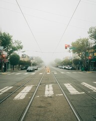 Fototapeta na wymiar Streetcart tracks on a foggy morning in West Portal, San Francisco, California