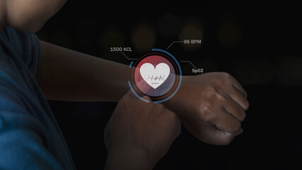 Man using smart watch technology checking heart rate with health app icon on the screen. Holographic icon user interface. Futuristic smart watch technology. Healthcare concept.