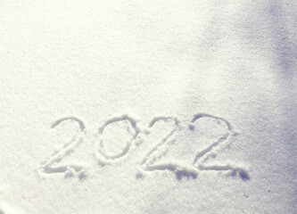 The inscription on the snow New 2022. Christmas Eve, winter day with snowfall. flying snowflakes. there are shiny winter snowdrifts on the ground, New Year's mood outside