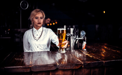 Girl bartender mixes a cocktail at the beerhouse