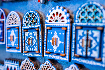 Chefchaouen, Morocco. October 10, 2021. Variety of small wooden door shaped design magnets for sale...