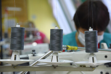 Skeins of thread mounted on an old sewing machine close-up, fabric production at the factory.