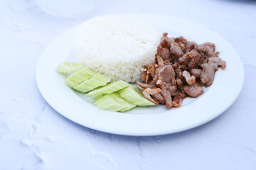 Pork with garlic with rice and cucumber, favorite menu in Thailand resturant.