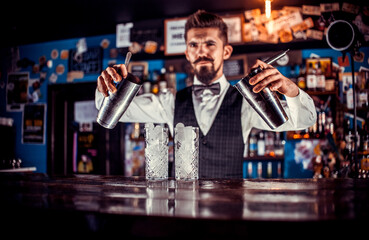 Focused bartending demonstrates his skills over the counter in the bar