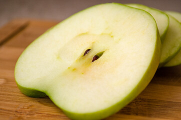sliced green apple on wooden cutting board
