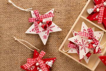 A set of Christmas toys made of wood in the shape of a star in a wooden box on sacking, close-up, top view.