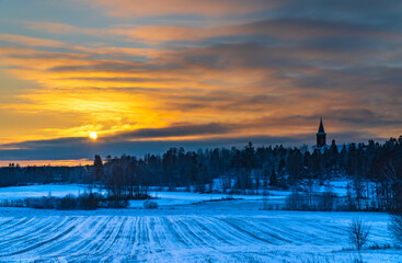 sunset over fields, church in the background