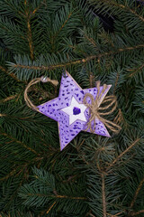 Christmas toy, decorated wooden star, on the branches of a Christmas tree, photo indoors with light