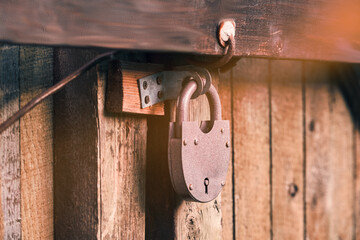 A large old padlock on a wooden door.