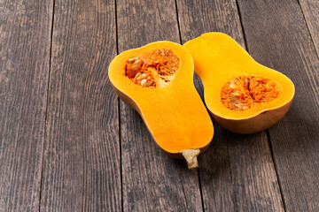 two halves of butternut squash on a wooden table, selective focus.