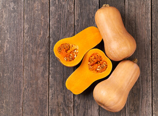 Butternut pumpkin on wooden table, top view. Butternut squash cut in half on a wooden table copy space for text.