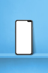 Mobile phone on blue wall shelf. Vertical background