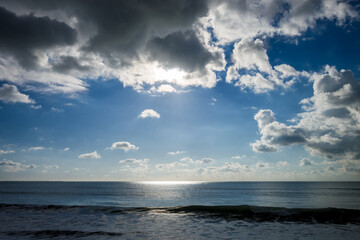 Naklejka na ściany i meble Cloudy seascape view from a beach at sunset