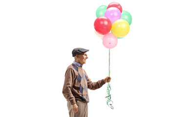 Elderly man holding a bunch of colorful balloons