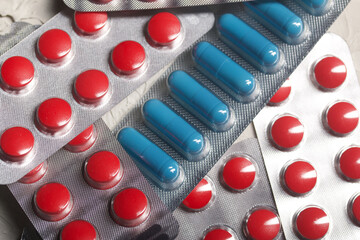 Blisters with red and blue tablets. On a light background. Close-up.