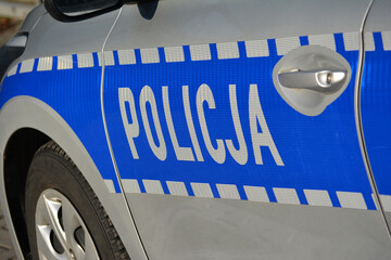 Znak policja na radiowozie polskiej policji zimową porą.