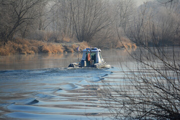 Łódź polskiej policji podczas zimowego patrolu na rzece.