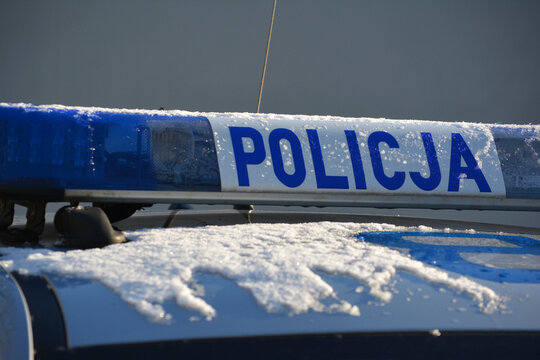 Znak policja na radiowozie polskiej policji zimową porą.