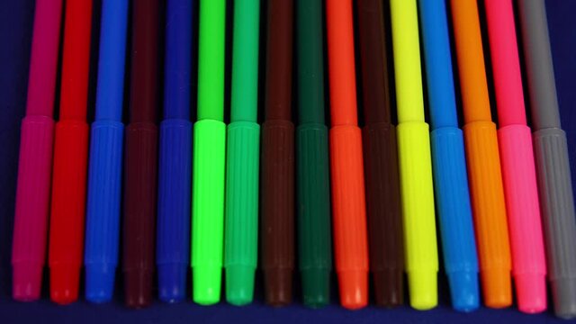 Close-up set of multicolored felt tip pen for kids on blue background, office supplies for art hobbyist,preparation for school.