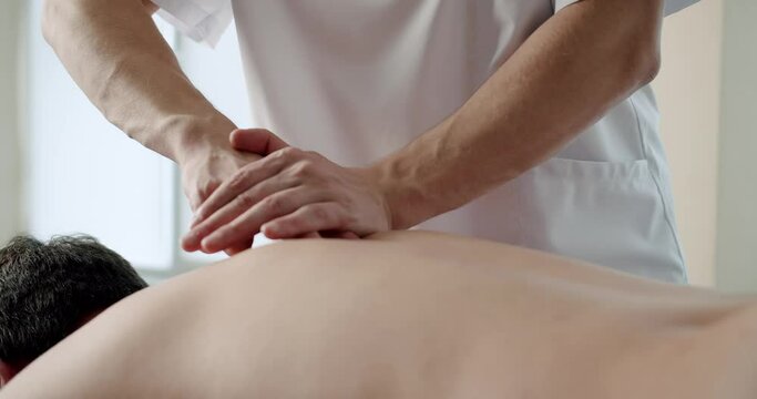 Professional massage of the back, spine, rehabilitation massage to a man