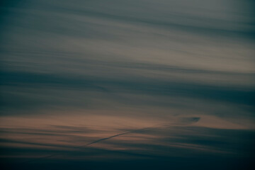 Dark abstract sunset clouds pattern. Dusk colors, orange pastel cloudscape, creative evening view. No selective focus, defocused background.