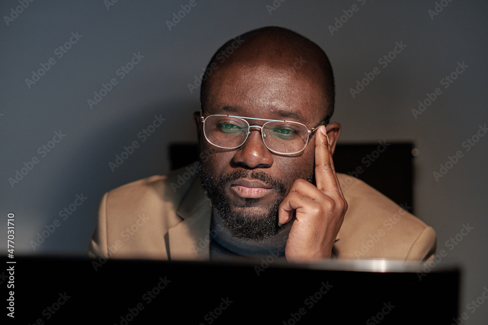 Aufkleber serious young businessman in eyeglasses and formalwear sitting in front of computer monitor while wo