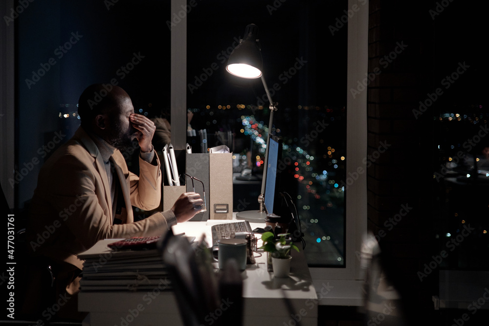 Aufkleber young exhausted businessman trying to concentrate while working in front of computer in office late 