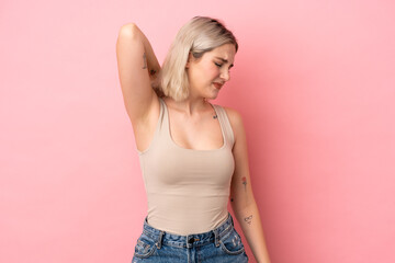 Young caucasian woman isolated on pink background with neckache