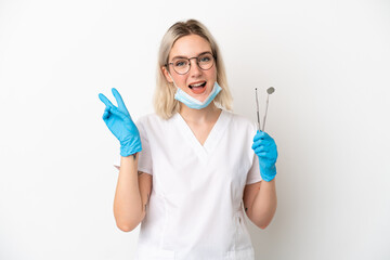 Dentist caucasian woman holding tools isolated on white background smiling and showing victory sign