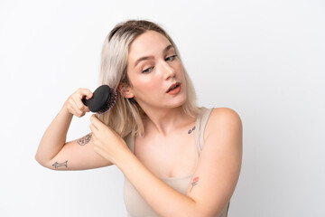 Fototapeta premium Young caucasian woman isolated on white background with hair comb