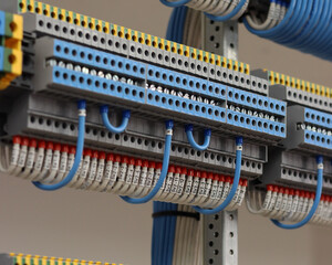 Colored electrical terminals with connected mounting wires on the din rail.