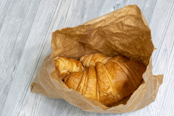 Freshly baked croissants in a brown paper bag.  Recycle plastic free packaging concept