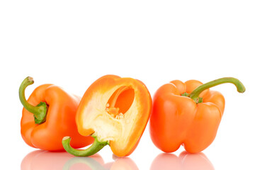 Two whole and one half of an orange fresh sweet pepper, close-up, isolated on white.