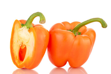 One whole and one half orange fresh sweet pepper, close-up, isolated on white.