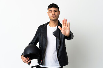 Man with a motorcycle helmet isolated on white background making stop gesture