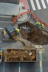 cavando un agujero en el suelo para reparar la canalización de agua o obras y canalización de agua en una calle con una  mini excavadora 