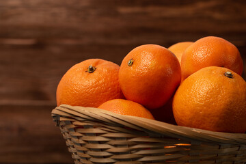 mandarines in a basket on a wooden background