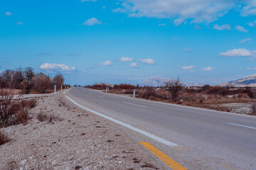 Asphalt road goes to the horizon. Landscape view perspective of road with white clouds on blue sky. Traveling by car. Trendy background for branding, calendar, multicolor card, banner, cover, header