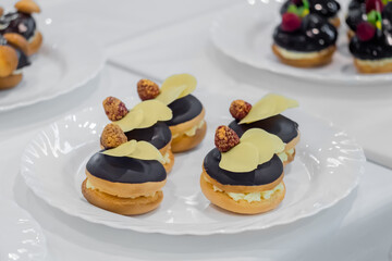 Close up: assortment of delicious fresh shortcrust tart cakes with cream and chocolate on white plate for sale at restaurant, cafe, bakery. Dessert, culinary, sweet food and confectionery concept