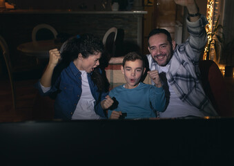 Father, mother and son celebrating victory of favorite sport club