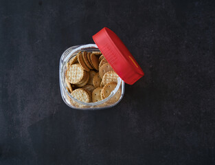 cookies in jar scattered on the table with black background